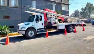 Camión grúa instalando señal en Autopista MEX-HGO