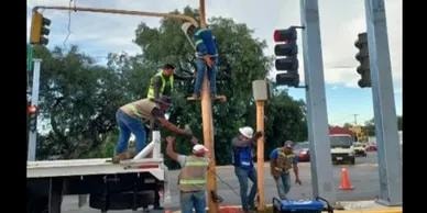 Trabajadores realizando mantenimiento en semáforo